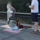 Ljudje se v koloni obnašajo kot na pikniku – sončijo se, rolkajo …