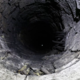 Žensko vrgel v šest metrov globok vodnjak in ji na glavo metal steklenice, rešili so jo sosedi