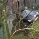 (FOTO) 20-letnik na mokri cesti vozil prehitro in z avtomobilom obstal med drevesi nad potokom